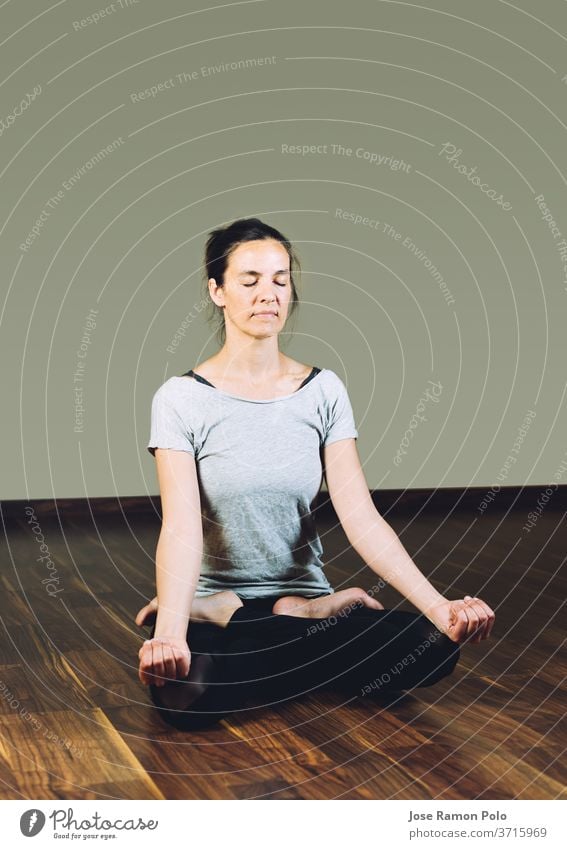 Woman Sitting Cross-legged with her Hands Clasped and Eyes Closed on a Yoga  Mat · Free Stock Photo