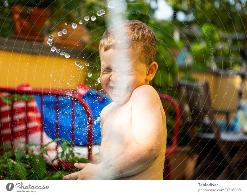 Boy is splashed with water on the terrace and laughs Water Inject Boy (child) Child Naked Skin Garden Balcony Terrace Paddling pool Garden Loop Drop