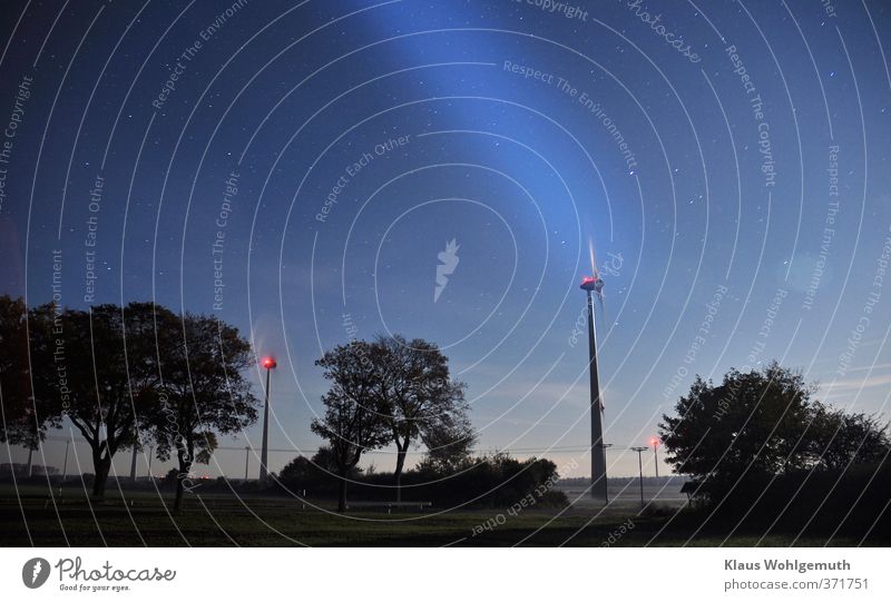 Angular power plants in the light of the October full moon, additional light effect with an LED flashlight. Energy industry Pinwheel Wind energy plant