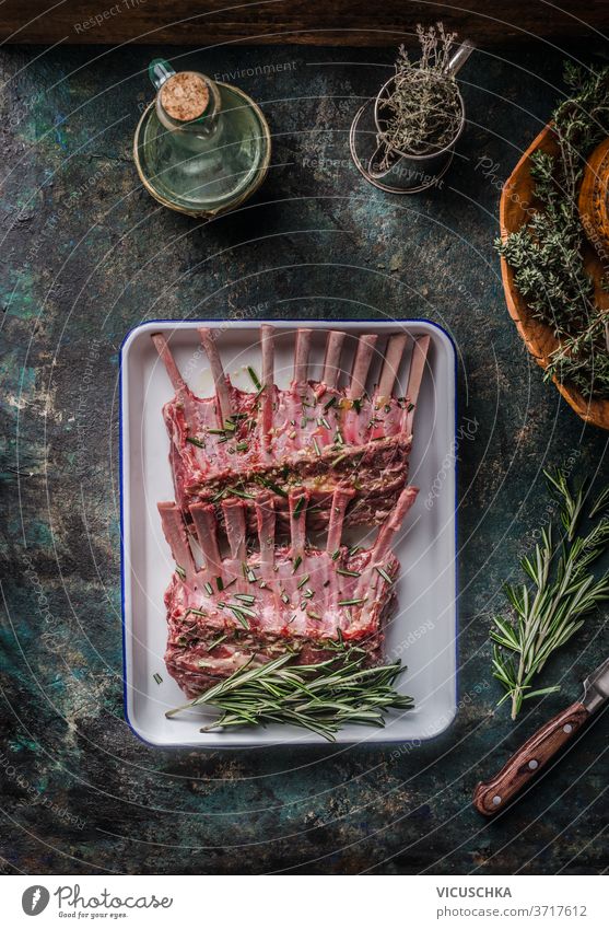 Raw lamb ribs with herbs and seasonings on a dark rustic kitchen background. Top view. raw spices around top view barbecue bbq bone butcher chop cooking cut
