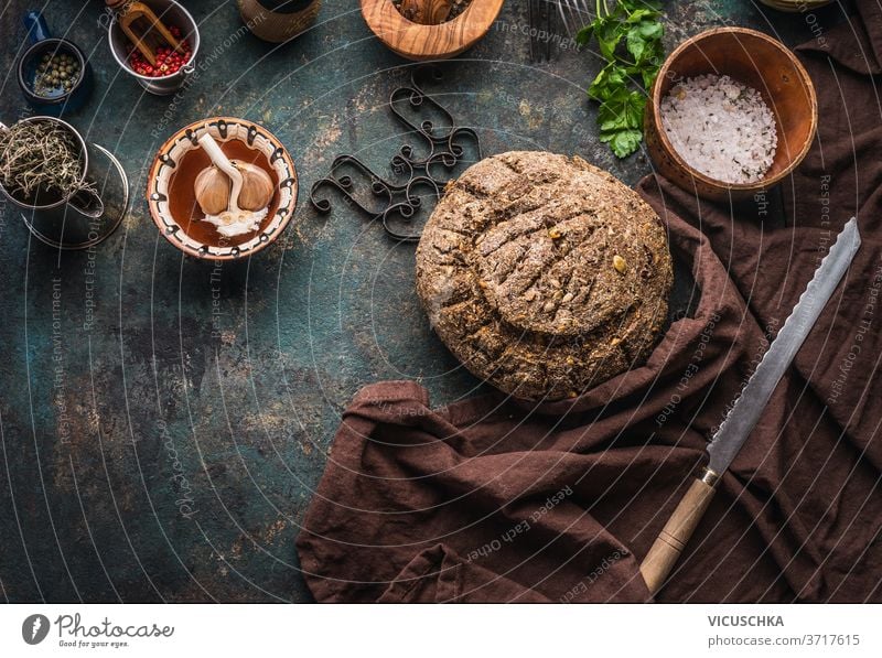 Homemade whole grain bread on dark kitchen table background with knife and cooking tools homemade ingredients top view place text bakery board breakfast brown
