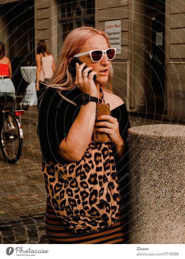 Young woman in the city centre of Regensburg on the phone Bavaria Seeightsing Leopard print sunglasses Summer Sun Fashion fashion design Colour photo