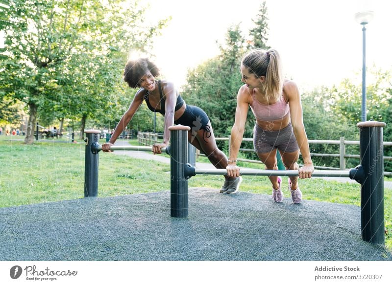 Sporty women doing push ups in park fitness training workout cheerful together exercise sporty friend young multiracial multiethnic diverse african american