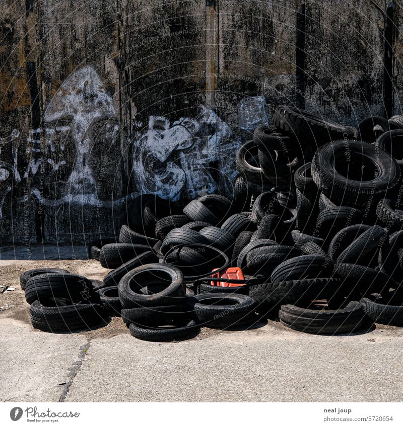 Petrol canisters in heaps of old car tires Trash Car tire Recycling Environmental pollution Canister Problem Rubber Plastic Contrast Black Red Trashy