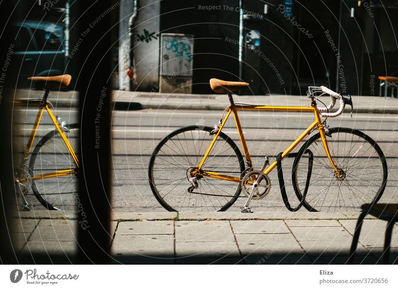 Yellow vintage road bike stands locked on the street in front of a shop Racing cycle completed bicycle lock Bicycle Cycling Retro Saddle leather saddle Sports