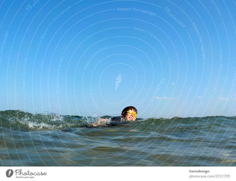 Boy swims in the sea Summer bathe be afloat Ocean Baltic Sea Summer vacation Swimming goggles Water Joy fun Sun holidays free time