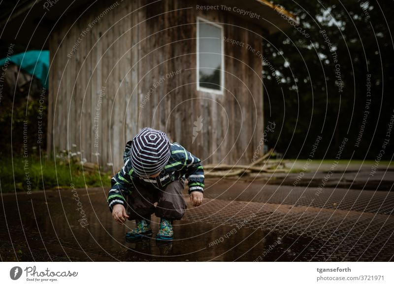 Boy plays in puddle Child Infancy Playing playing children Effortless Boy (child) Exterior shot Joy people Puddle Discover Observe 1 - 3 years Parenting Toddler