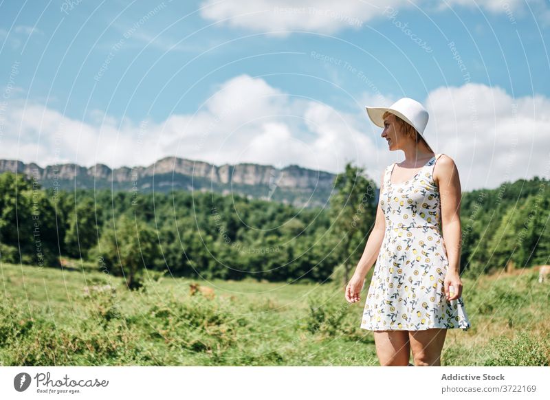 Tranquil woman in field in summer meadow mountain valley carefree serene cow pasture highland female dress hat grass peaceful green nature freedom tranquil hill