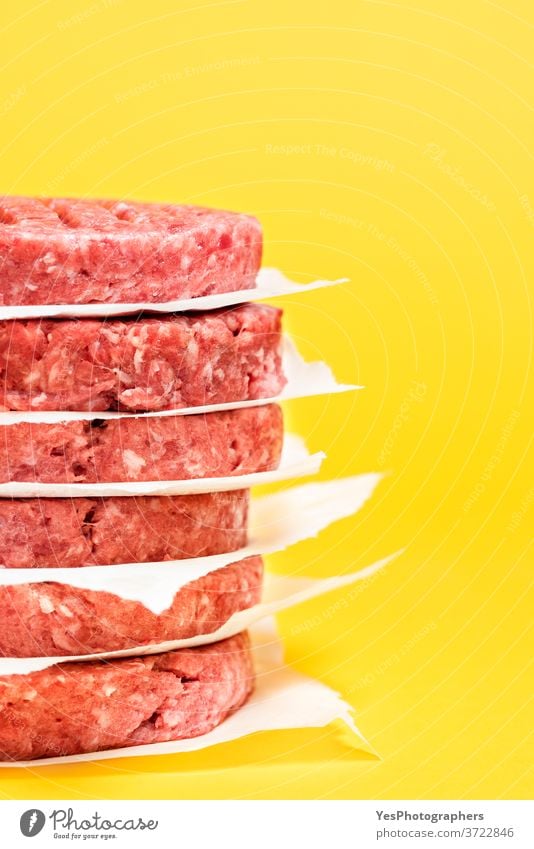 Raw beef patties close-up. Burger patties stacked against a yellow background. barbeque bbq burger butcher comfort food cooking cow meat cuisine culinary