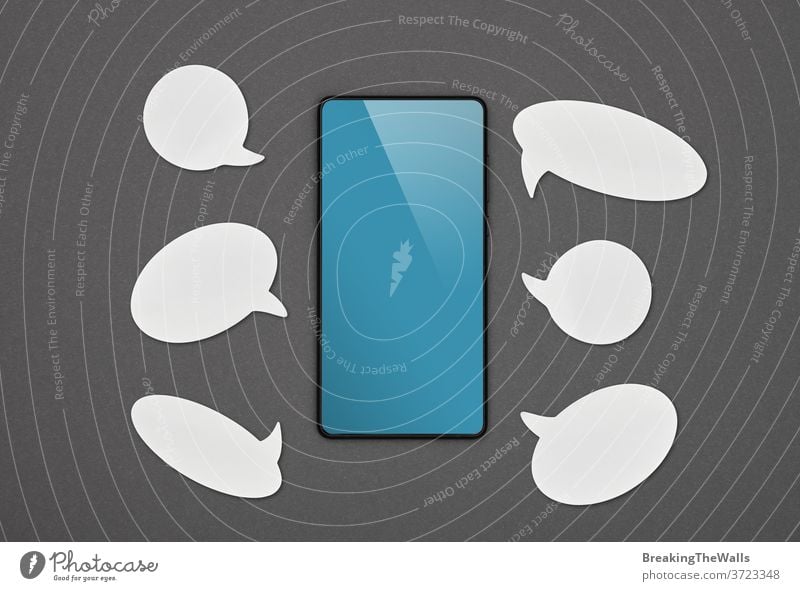 Black smartphone with callouts over grey black background screen blue blank empty bubble white closeup cellphone pda flat lay directly above top view high angle