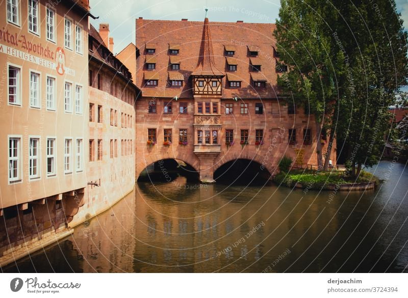 Spital Apotheke Nuremberg, old-style architecture. A river flows through the building. Next to it is a tree. Franconia Architecture Building Exterior shot