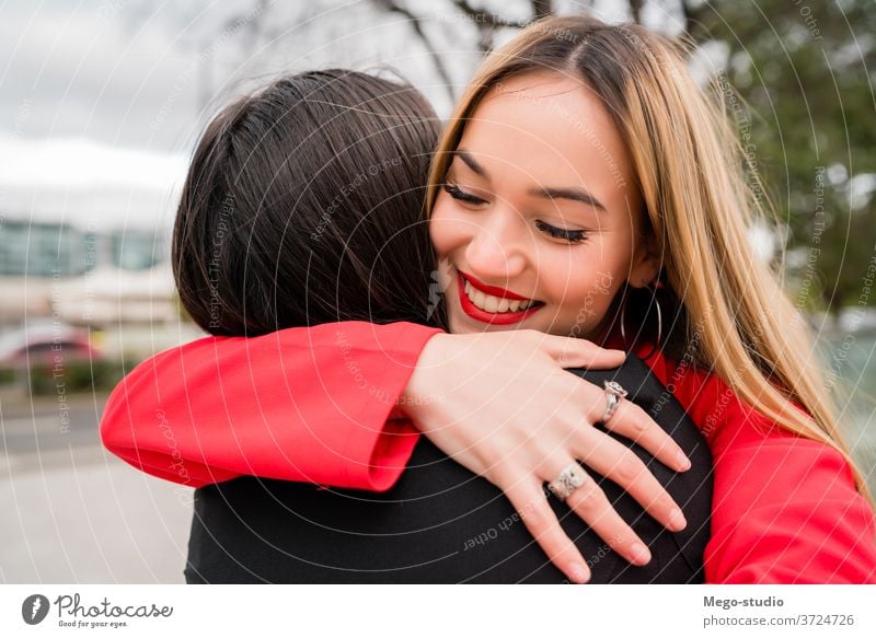 Two young friends hugging each other. two friendship positive expressing playful cute meeting outdoors youth cuddling relationship portrait person friendly