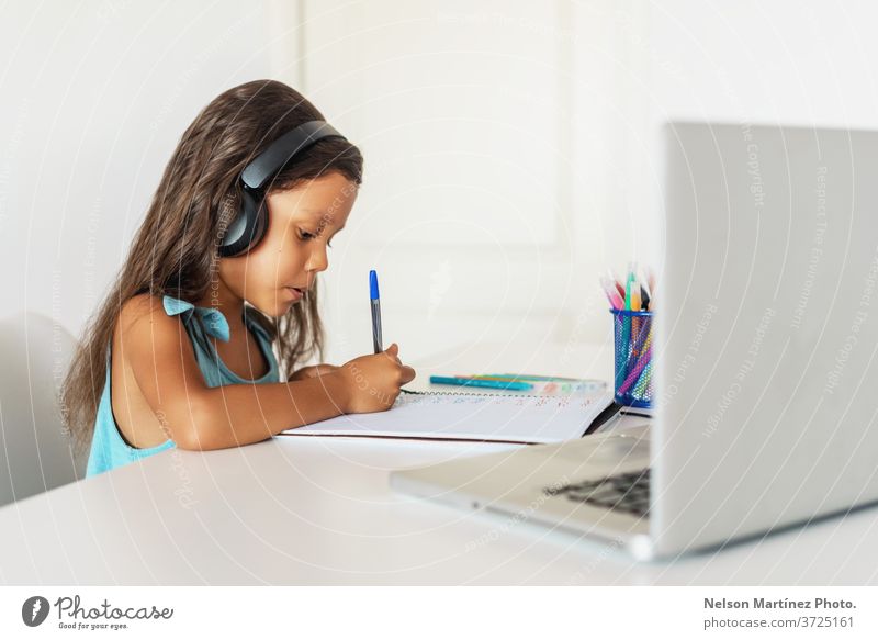 Little hispanic girl studying in front of the laptop. E-learning, study at home online. computer children young video school education e-learning technology