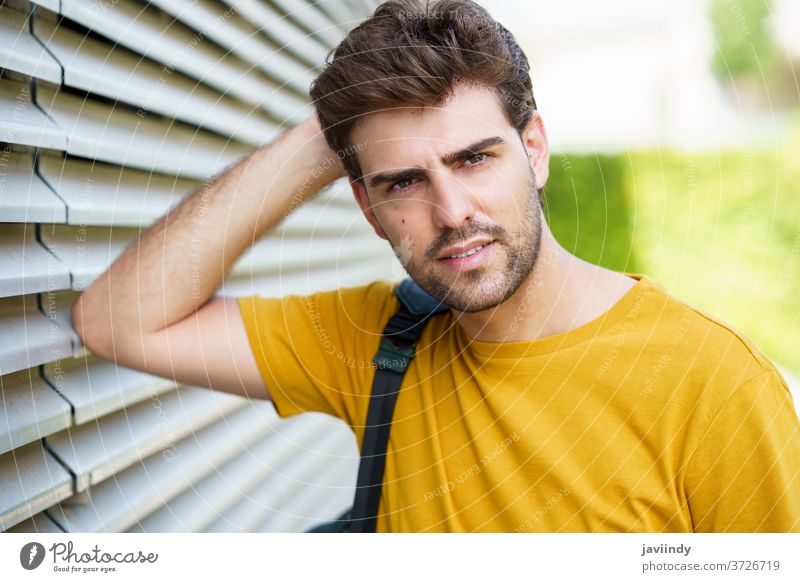 Young man with modern haircut in urban background male hairstyle student lifestyle cool person casual adult young outdoors street city trendy model caucasian