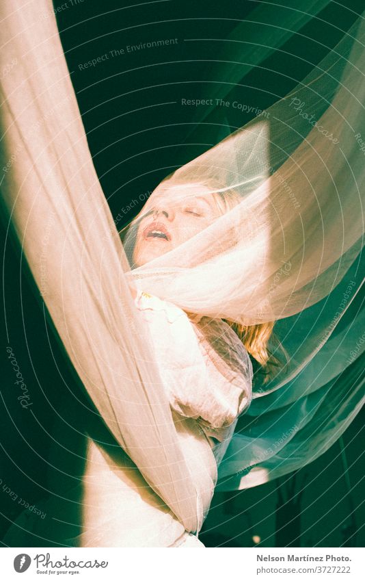 Portrait of a blonde woman. She is with open arms, wrapped in tulle curtains. bonde artist natural light freedom sensual portrait caucasian Portrait photograph
