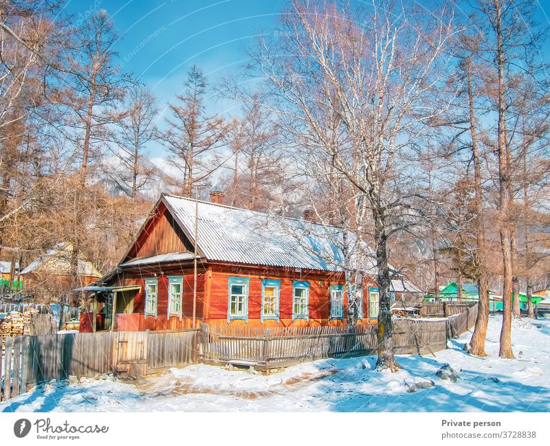 Picturesque wooden house in the forest on a sunny winter day. Snow, blue sky, mountains in the background. Healthy lifestyle concept, rural life. village white