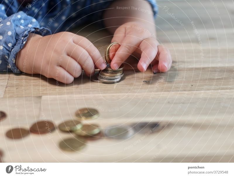 Child plays with coins and sorts them. Child's play, curiosity, pocket money Coin Cent children's hands Children's game Money finance child benefit family money