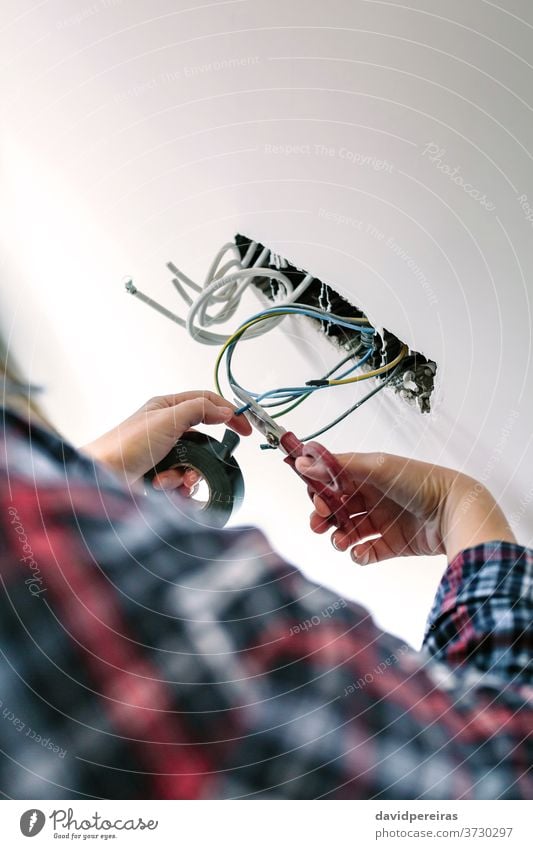 Unrecognizable electrician working on the electrical installation of a house unrecognizable electrical technician cutting cable danger scissors electric cable