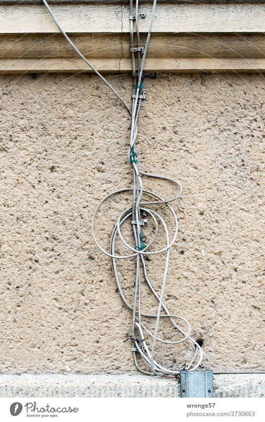 jumble of old cables on a house wall disorientation Muddled muddled Terminal connector Cable wires Telephone cable Colour photo Technology Chaos
