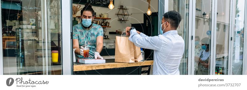 Man picking up take away food order man food delivery protective mask face mask restaurant only take away banner web panorama header panoramic lunch street