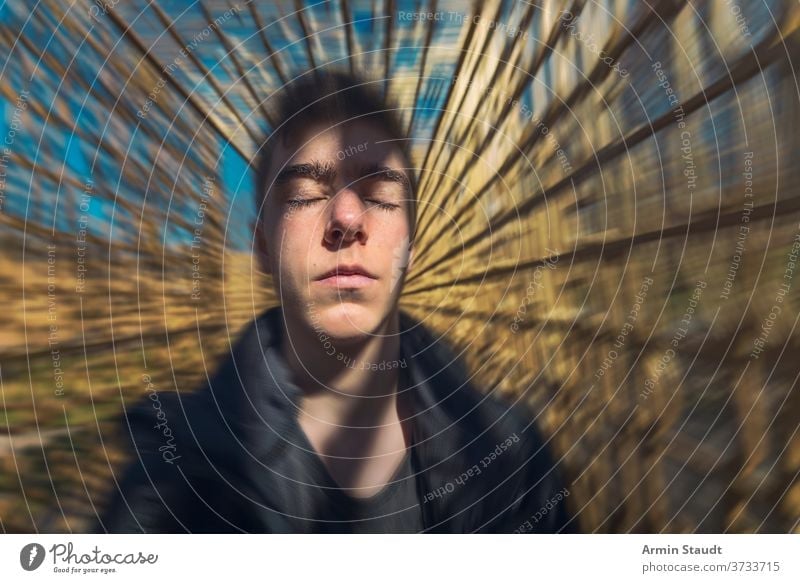 portrait of a dreaming young man with moving background meditation concentration imagination inspiration serious beautiful handsome dynamic speed motion blur