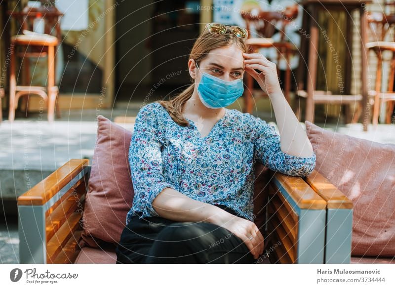 Young woman with mask outdoors in coffee shop thinking 2020 adult beautiful caffè caucasian city concept coronavirus covid-19 every day life