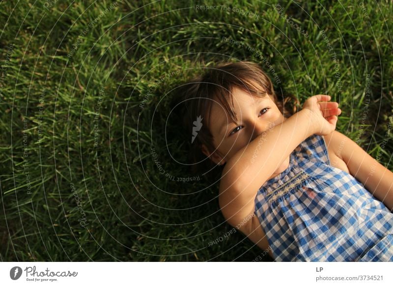 little girl laying on the grass, looking at the sky Upper body Portrait photograph Pattern Structures and shapes Abstract Exterior shot Subdued colour