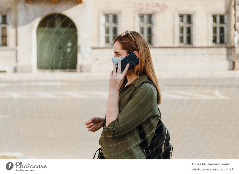 Woman with face mask talking on the phone outside, profile view 2020 adult beautiful blue caffè caucasian child childhood city concept coronavirus covid-19