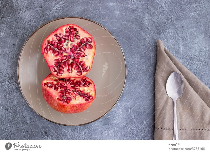 Pomegranate fruit cut in half and served on a plate antioxidant antioxidants backgrounds beauty bowl close close-up colours concept dark dessert dieting exotic