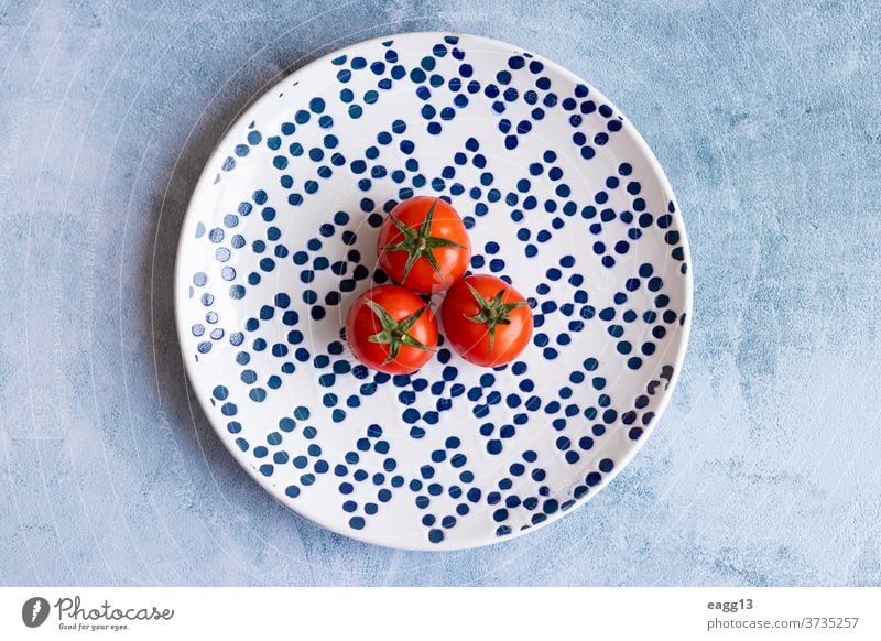 Cherry tomatoes on blue dotted plate abundance alimentation backgrounds cherry chic close-up colors colourful colours composition diversity eco ecology farming