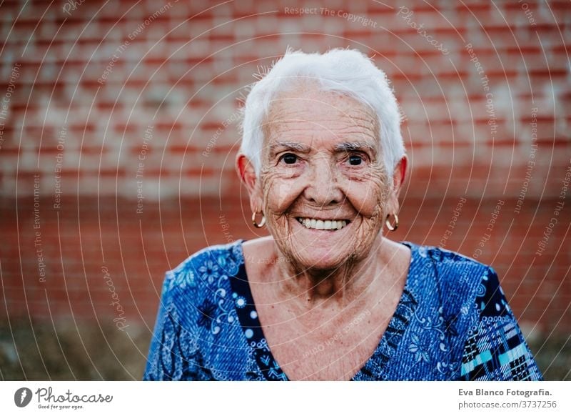portrait of old lady in her 80s smiling outdoors - a Royalty Free