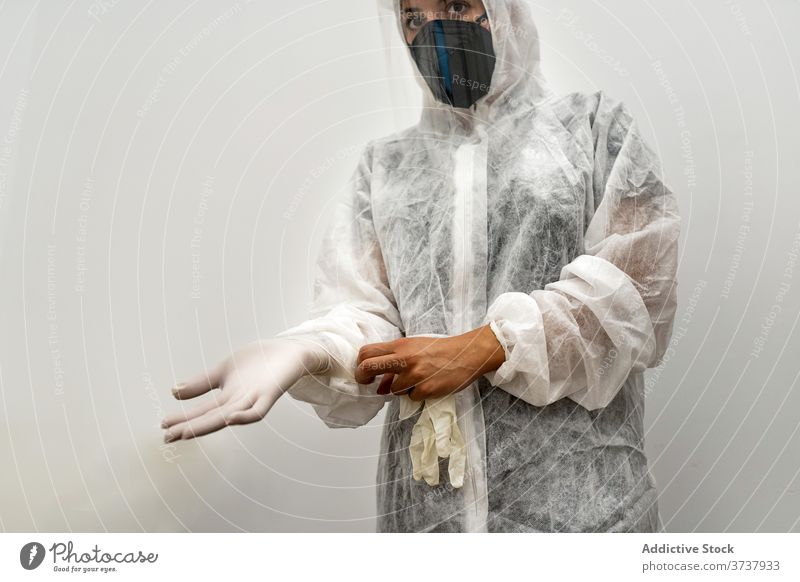 Desperate medical NHS EMS worker in white protective suit,blue surgical  mask latex gloves & safety goggles,Coronavirus COVID-19 pandemic crisis  causing shortage of protective personal equipment supply Stock Photo