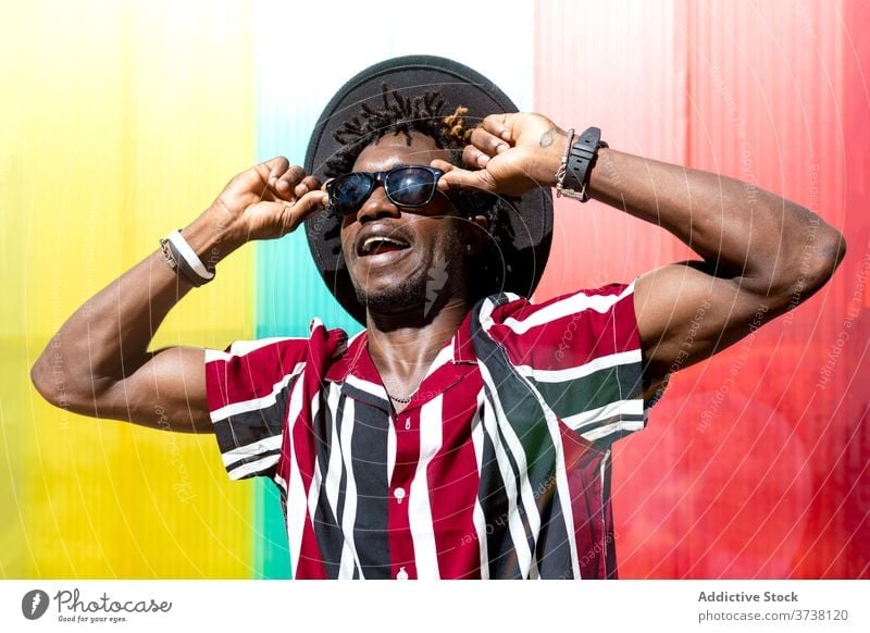 Stylish ethnic man in sunglasses and hat - a Royalty Free Stock Photo from  Photocase