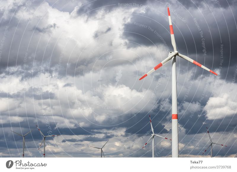 modern wind wheels in front of a cloudy storm sky wind turbine wind turbines cloudy sky stormy sky clouds storm clouds green energy wind energy electricity