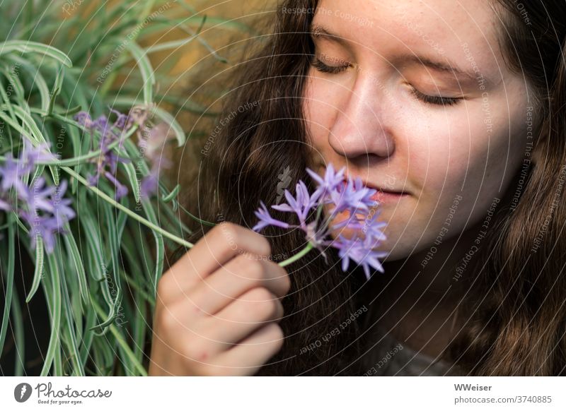 Young girl sniffs the garlic flower with relish Young woman Nose Fragrance flavor Odor Garlic Intensive Garden flowers natural Nature sharp spicy To enjoy
