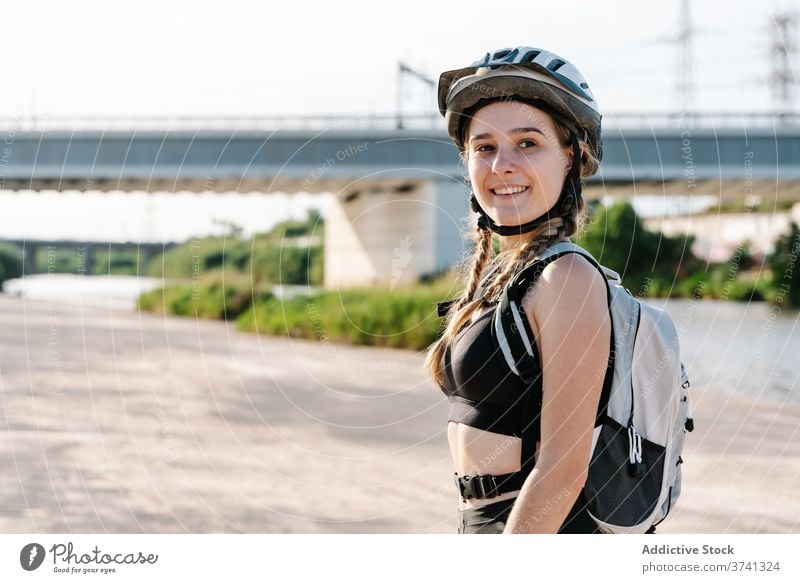 Portrait of slim young female in sportswear looking at camera woman cyclist sporty activity rest helmet exercise bottle biker break thirst healthy lifestyle