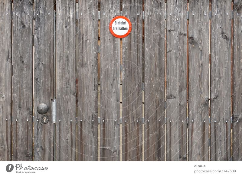 a big brown wooden gate with a small sign "Keep the entrance free" Wooden gate Goal Signage keep the driveway clear Main gate Holtor Get Signs and labeling