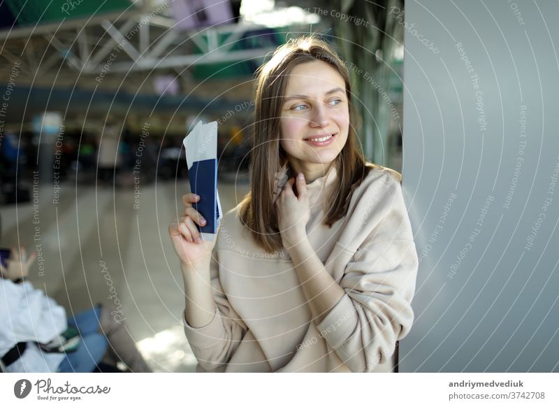 portrait of happy young woman holding passport and boarding pass at airport flight girl travel traveller passenger female journey trip beautiful pretty
