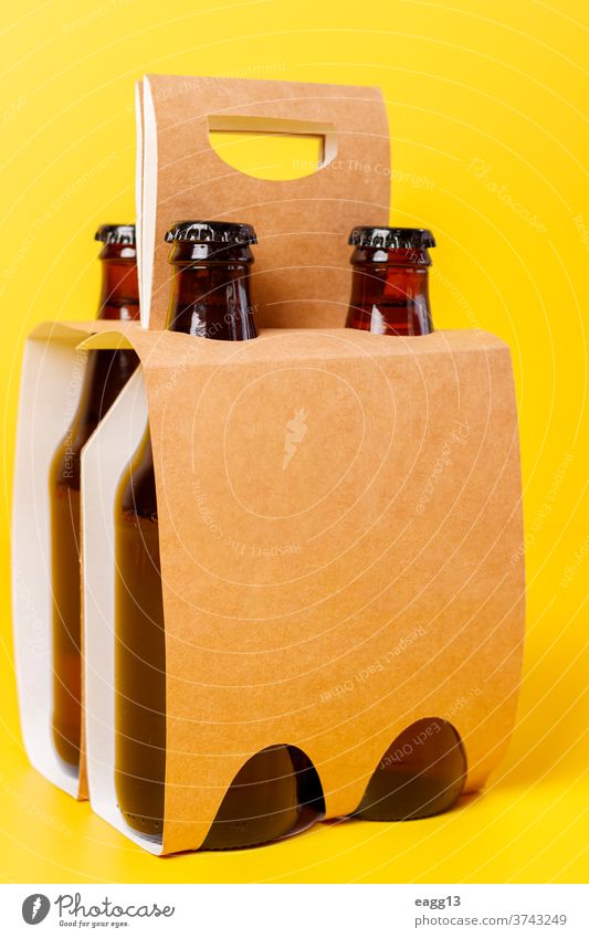Presentation of pack of four beers with yellow background ale bavarian belgian beverage booze bottle bottles box brand branding brewery carton case container