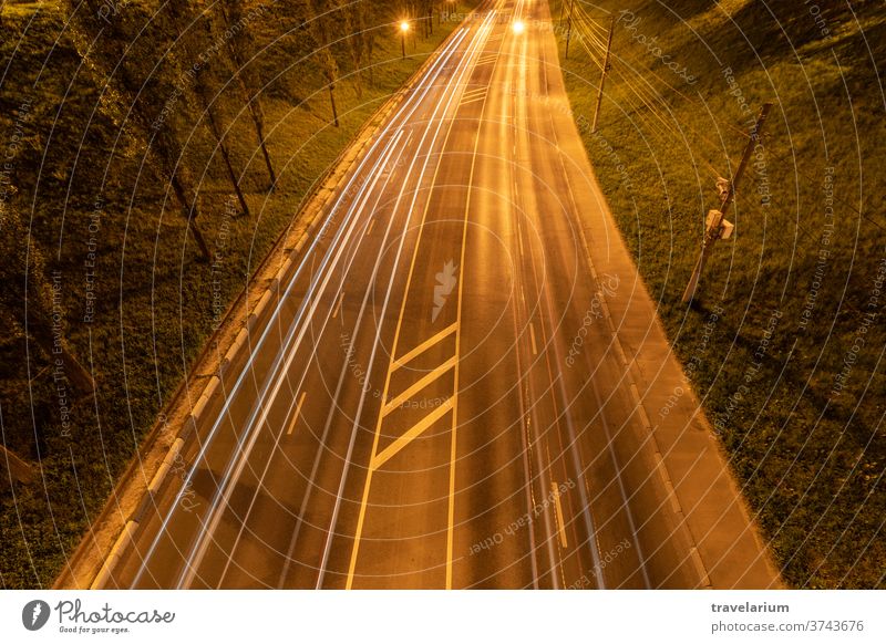 Night highway with car light streaks. Night light painting stripes. Long exposure photography. Copy space retro wave road night path speed long line trail