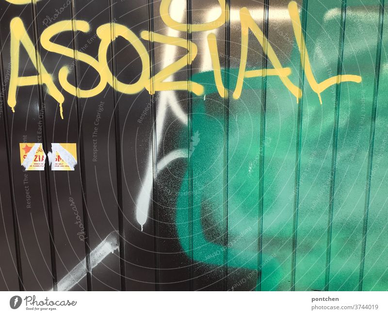 Antisocial stands on a garage door. Graffiti. Social criticism asocial Daub Remark social criticism Characters Garage door illicit Text Letters (alphabet) Word