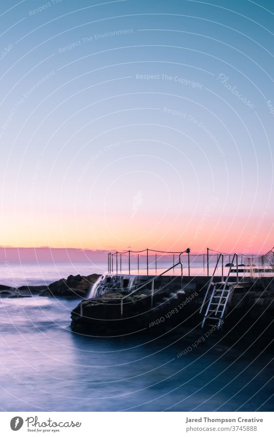 A pink spring sunrise overlooking Bronte Baths in Sydney, Australia. bronte baths ocean pool pools australia nsw newsouthwales eastcoast beach rocks summer