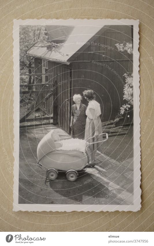 Memories of the 1960s - black-and-white picture with deckle edged paper shows three generations in a front garden / fashionable pram and mother talking to grandmother