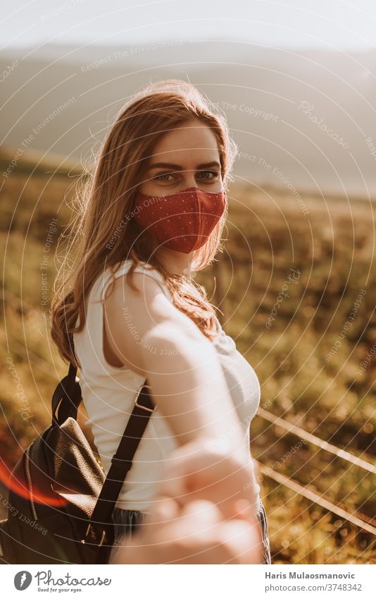 Young woman with mask going to adventure holding hand of her boyfriend attractive backpack beautiful beautiful landscapes beautiful woman beauty caucasian