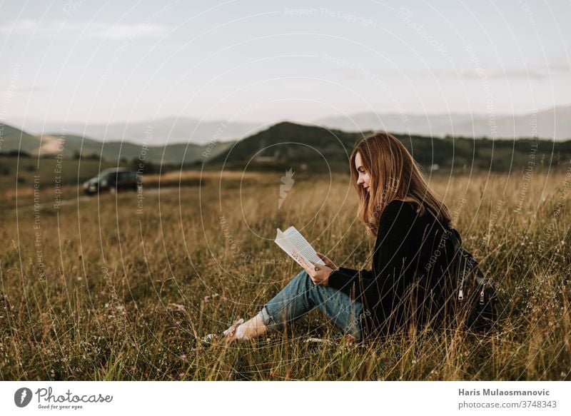 Young beautiful blonde hair woman solo traveler reading a book in nature alone away from the city beauty concept countryside escape from city feeling female