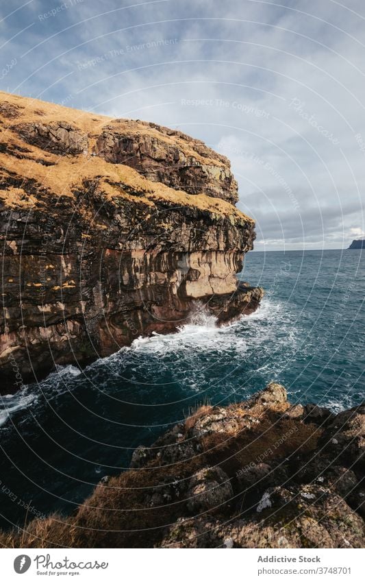 Rocky cliff near sea on Faroe Islands rock seascape winter season cold steep terrain faroe islands rocky scenery majestic coast shore water sky calm overcast