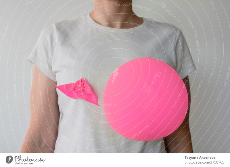 Woman checking her very large breasts for cancer on pink