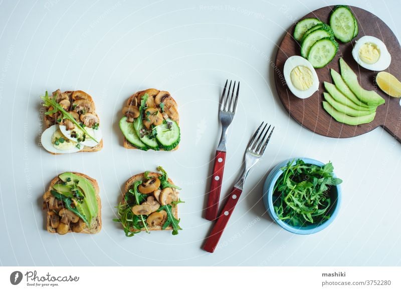 various morning vegetarian toast set with mushrooms, avocado, arugula, cucumber and eggs. Healthy food on white background bread vegetable sandwich breakfast