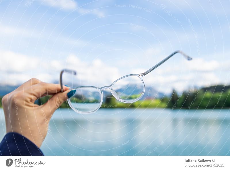 Glasses in front of beautiful nature Eyeglasses Nature nearsighted Looking Eyes Vision Person wearing glasses Optician Opthalmology Healthy Colour photo Optics