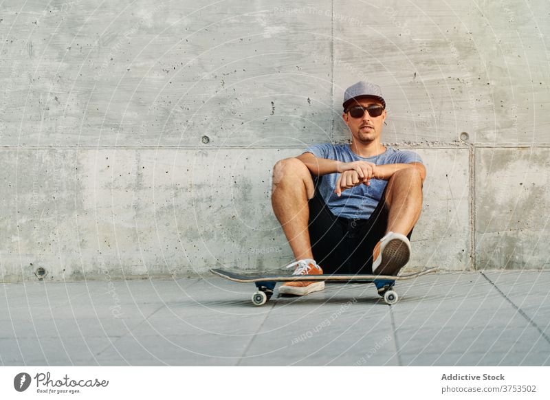 Stylish man with skateboard in city - a Royalty Free Stock Photo from  Photocase